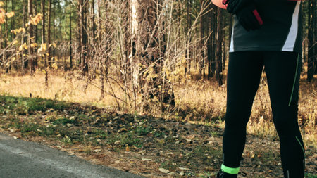 Training an athlete on the roller skaters. Biathlon ride on the roller skis with ski poles, in the helmet. Autumn workout. Roller sport. Adult man riding on skates. The athlete does the workout.の写真素材
