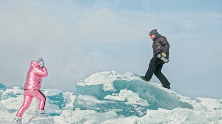 Couple has fun during winter walk against background of ice of fの写真素材