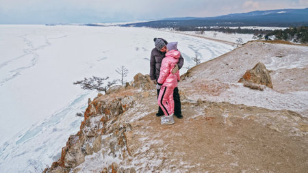 Young couple enjoying walking outdoors in winter top mountains.の写真素材