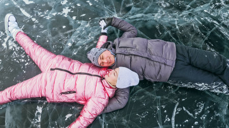 Couple has fun during winter walk against background of ice of fの写真素材