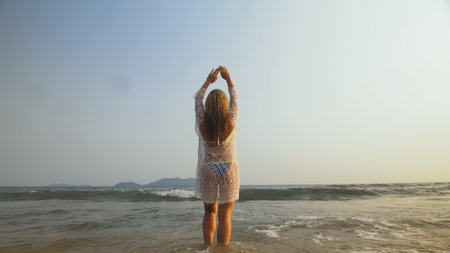 Woman is Wetting her Hair in a White Tunic on the Beach, near thの写真素材