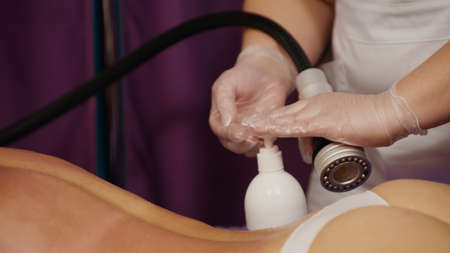 Woman receiving anti-ageing anti-cellulite massage vacuum rf lifting in spa salon. Wellness body and skin care.の写真素材