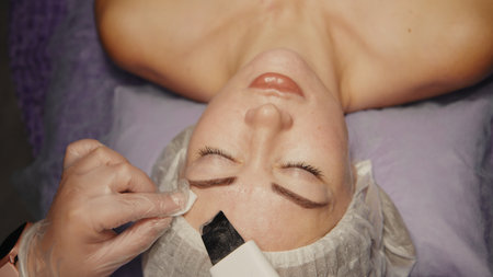 Woman cleansing facial in spa salon. Water oxygen face h2o2 small bubble facial rf lifting equipment skin care microdermabrasion machineの写真素材