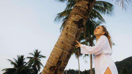 Woman in a white tunic shirt on beach, near stormy sea, tilted pの写真素材