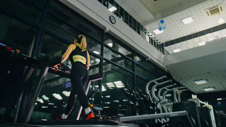 Fit Athletic Woman Running on the Treadmill, Doing Her Fitness Eの写真素材