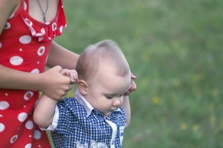 The girl holds the little boy for hands, helps it to go の写真素材