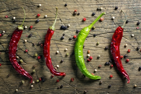 Red and green chili peppers and pepper mix on vintage wooden table backgroundの写真素材