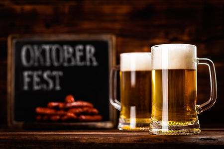two glass mug of fresh beer as oktoberfest backgroundの写真素材
