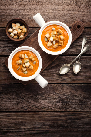 pumpkin soup in bowl on wooden tableの写真素材