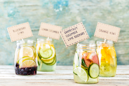 Variety of fruit infused detox water in jars for a healthy dietの写真素材