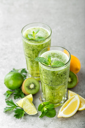 fat burning green fruit cocktail with kiwi, lemon, mint and parsley for slimming and healthy dietの写真素材