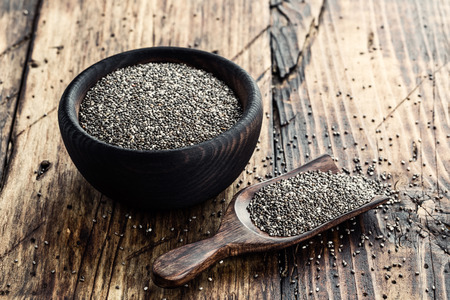 Chia seeds in a wooden bowl on a wooden rustic backgroundの写真素材