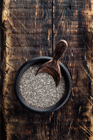 Chia seeds in a wooden bowl on a wooden rustic backgroundの写真素材