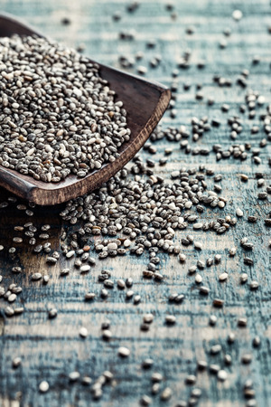 Chia seeds in a wooden scoop on a wooden rustic backgroundの写真素材