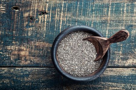 Chia seeds in a wooden bowl on a wooden rustic backgroundの写真素材