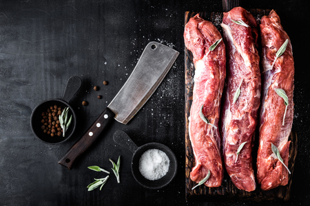 fresh raw pork tenderloin on wooden cutting board on dark background and blank space for your text
の写真素材