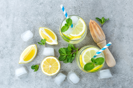 Lemonade or mojito cocktail with lemon and mint, cold refreshing drink or beverage with iceの写真素材