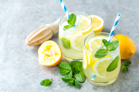 Lemonade or mojito cocktail with lemon and mint, cold refreshing drink or beverage with iceの写真素材