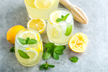 Lemonade or mojito cocktail with lemon and mint, cold refreshing drink or beverage with iceの写真素材