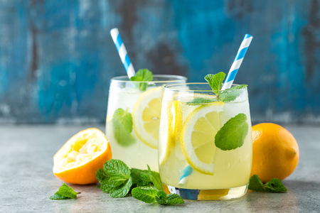 Lemonade or mojito cocktail with lemon and mint, cold refreshing drink or beverage with iceの写真素材