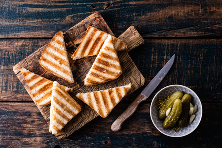 hot toasted sandwich panini with ham and cheese on wooden cutting boardの写真素材