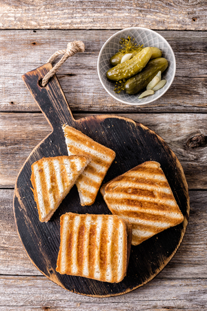 hot toasted sandwich panini with ham and cheese on wooden cutting boardの写真素材