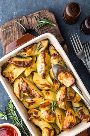 crispy spicy baked potatoes in baking dishの写真素材
