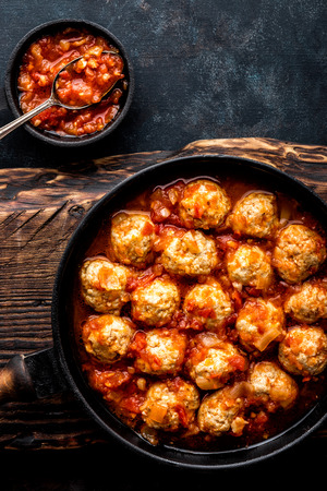 Homemade meatballs stewed in tomato sauce in cast iron panの写真素材