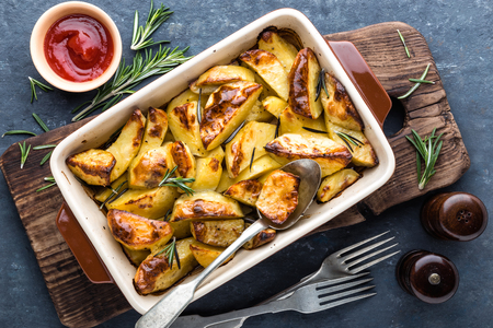 crispy spicy baked potatoes in baking dishの写真素材