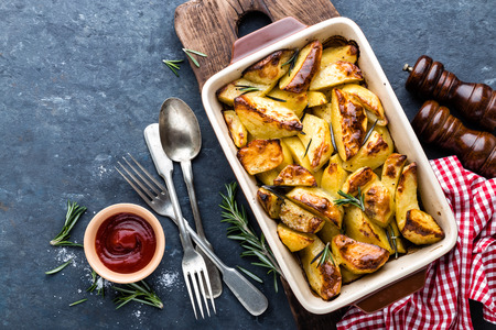 crispy spicy baked potatoes in baking dishの写真素材
