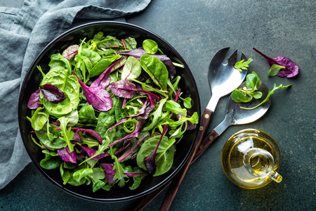 Fresh salad mix of baby spinach, arugula leaves, basil, chard and lambs lettuce. Salad bowl, healthy food, top viewの写真素材