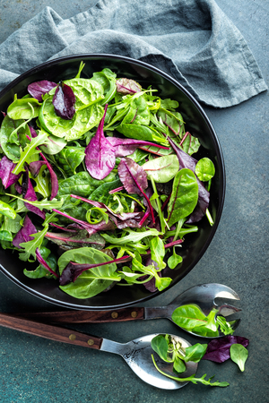 Fresh salad mix of baby spinach, arugula leaves, basil, chard and lambs lettuce. Salad bowl, healthy food, top viewの写真素材