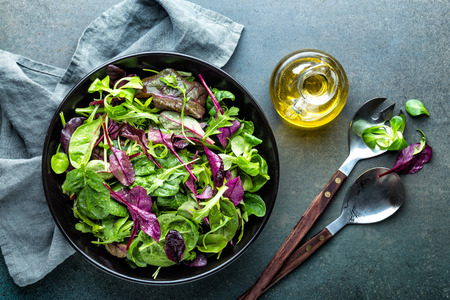Fresh salad mix of baby spinach, arugula leaves, basil, chard and lambs lettuce. Salad bowl, healthy food, top viewの写真素材