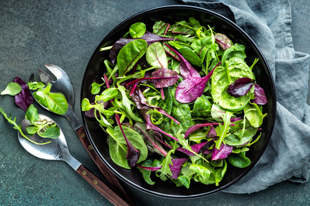 Fresh salad mix of baby spinach, arugula leaves, basil, chard and lambs lettuce. Salad bowl, healthy food, top viewの写真素材