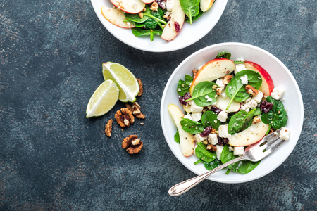 salad bowl of spinach, apple, soft cheese, nuts and cranberry. top view, healthy diet eating, superfoodの写真素材