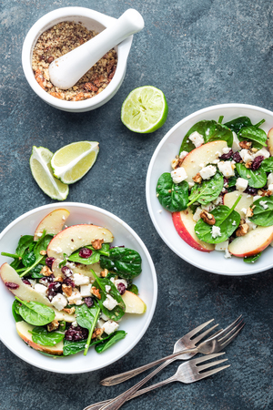 salad bowl of spinach, apple, soft cheese, nuts and cranberry. top view, healthy diet eating, superfoodの写真素材