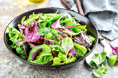 Fresh salad mix of baby spinach, arugula leaves, basil, chard and lambs lettuce. Salad bowl, healthy foodの写真素材