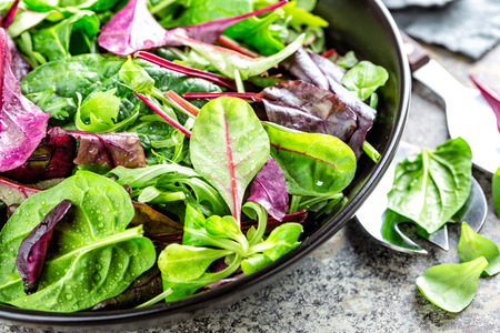 Fresh salad mix of baby spinach, arugula leaves, basil, chard and lambs lettuce. Salad bowl, healthy foodの写真素材