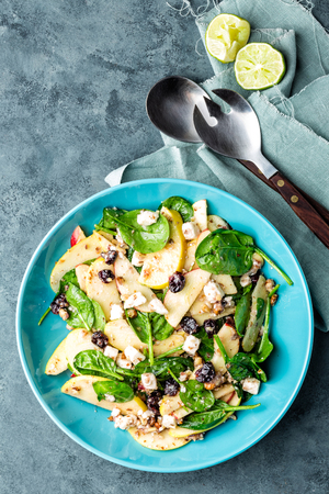salad bowl of spinach, apple, white cheese, nuts and cranberry. top view, healthy diet eating, superfoodの写真素材