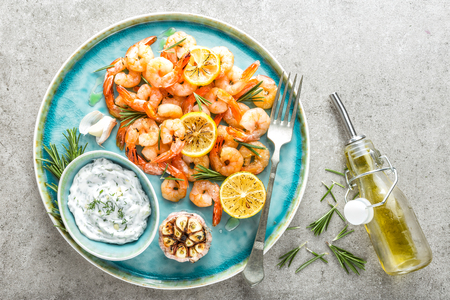 Grilled shrimps or prawns served with lemon, garlic and sauce. Seafood. Top view. の写真素材