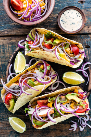 Mexican tacos with chicken meat, vegetables and fresh greensの写真素材