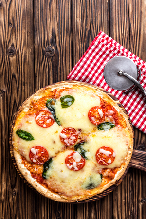 pizza margarita top view on a rustic wooden table, Margherita  cooked according to the traditional recipe of Italian cuisineの写真素材