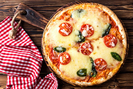 pizza margarita top view on a rustic wooden table, Margherita  cooked according to the traditional recipe of Italian cuisineの写真素材