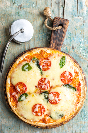 pizza margarita top view on a rustic wooden table, Margherita  cooked according to the traditional recipe of Italian cuisineの写真素材