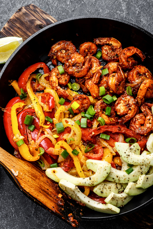 shrimp fajitas with bell pepper and onion cooked in a frying pan, top viewの写真素材