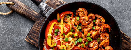shrimp fajitas with bell pepper and onion cooked in a frying pan, top view, bannerの写真素材