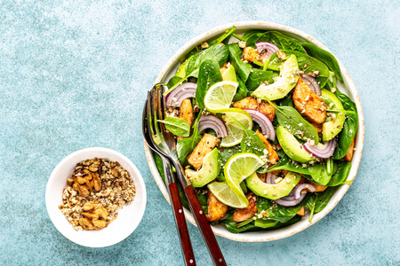Healthy avocado salad with chicken breast and spinach, flat lay, top viewの写真素材