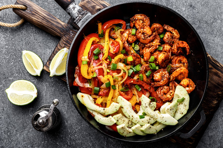 shrimp fajitas with bell pepper and onion cooked in a frying pan, top viewの写真素材