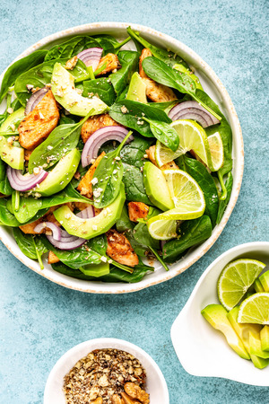 Healthy avocado salad with chicken breast and spinach, flat lay, top viewの写真素材