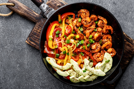 shrimp fajitas with bell pepper and onion cooked in a frying pan, top viewの写真素材